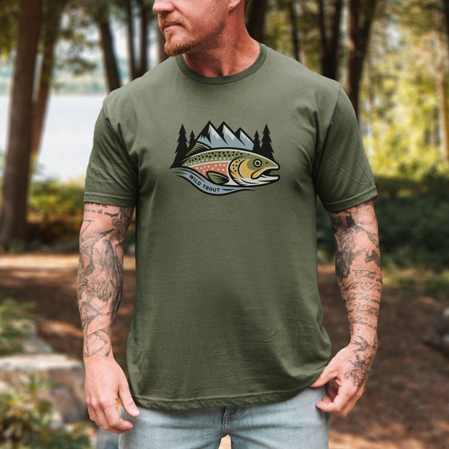 Man wearing a green t-shirt with a fish graphic in a forest setting